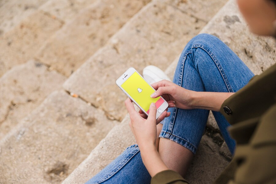 female holding phone, snapchat displayed